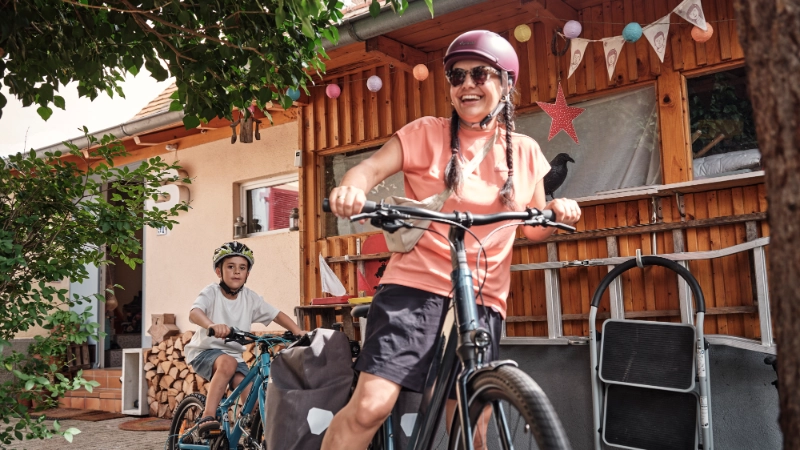 Frau und Kind fahren mit Follow-Me Kupplung zuhause los Frau und Kind fahren mit Follow-Me Kupplung zuhause los