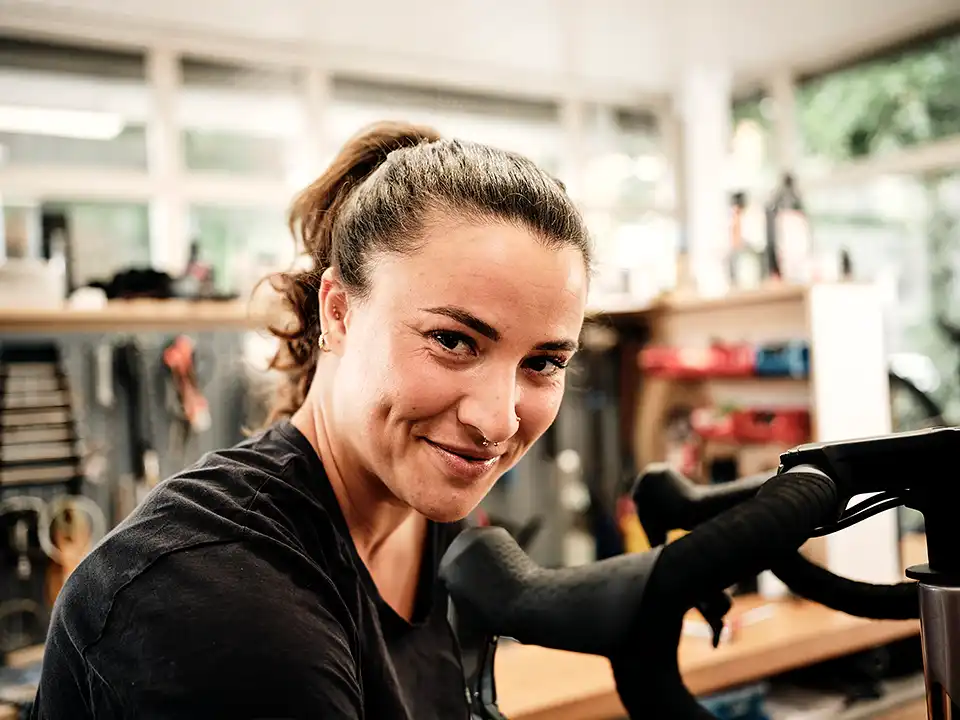 Fahrradmechanikerin schaut in die Kamera
